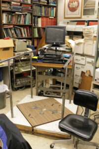 Photograph of John Gianutsos' office on January 20, 2008, the day that he died. The platform in the middle was a balance platform that he developed to use with paralyzed patients in order to give biofeedback, which was instantaneous, as opposed to previous models which would be feedback that was reviewed the next week when a patient had another appointment. This was revolutionary at the time in the mid-80s.