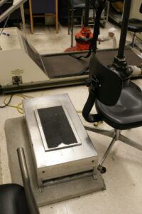Photograph of John Gianutsos' office on January 20, 2008, the day that he died. The silver box with the anti-skid tape on the plate on top was used as a shaker. This vibration would induce involuntary spasm of the muscles in a patient's leg in order to maintain muscle tone.